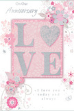 This anniversary card captures the essence of enduring romance with a design as soft and sincere as a hand-delivered bouquet in Sutton. At its heart sits the word LOVE, created in raised, glittered letters that shimmer delicately rather than sparkle boldly. The glitter tone harmonises blush pink with a cool silver glint, echoing the gentle contrast of pale roses and silvery foliage. The letter O is transformed into a silver, textured heart, slightly domed and noticeably embossed so that it stands out both visually and by touch, symbolising the cherished bond between two people. Framing this central motif, a cluster of delicate blooms in blush and mauve unfurls across the card, their edges softened like watercolour washes. The petals seem to blend into the pastel pink background, suggesting the lightness of flowers drifting in a mild Sutton breeze along the streets near Benhill or Collingwood Road. Fine, flowing lines sketch in the stems and leaves, weaving around the flowers in loose curls that give the design a sense of motion. Tiny flourishes-petals, dainty swirls, and faint butterfly silhouettes-add whimsical detail without disturbing the calm mood. The background itself is a gentle, powdery pink, subtly shaded to draw the eye toward the centre. Above and below the floral cluster, the phrases On Our Anniversary and I love you today and always are rendered in elegant script, their strokes echoing the natural curves of the vines. Together, these elements form a quiet yet heartfelt tribute, ideal for celebrating a shared journey of love in Sutton.